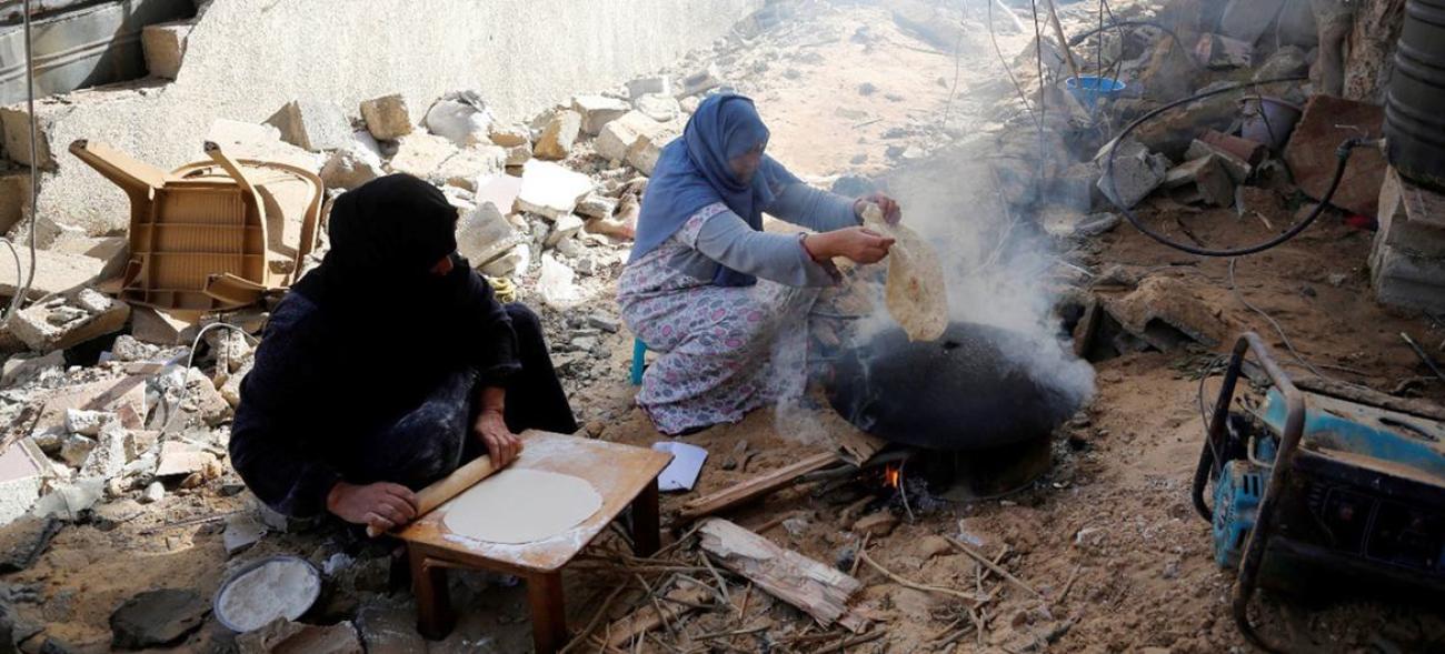 Gazze'de insani ateşkes sırasında ekmek pişirmeye çalışan kadınlar