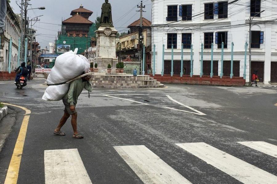  Nepal'in Katmandu şehrinde gündelik işlerde çalışan bir kişi yük taşıyor. 